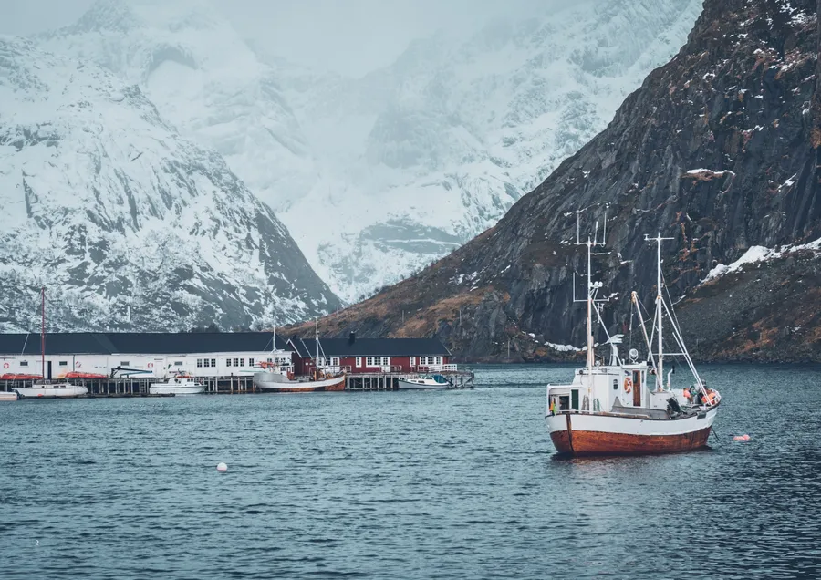 Norsk fiskehavn med fjell i bakgrunnen